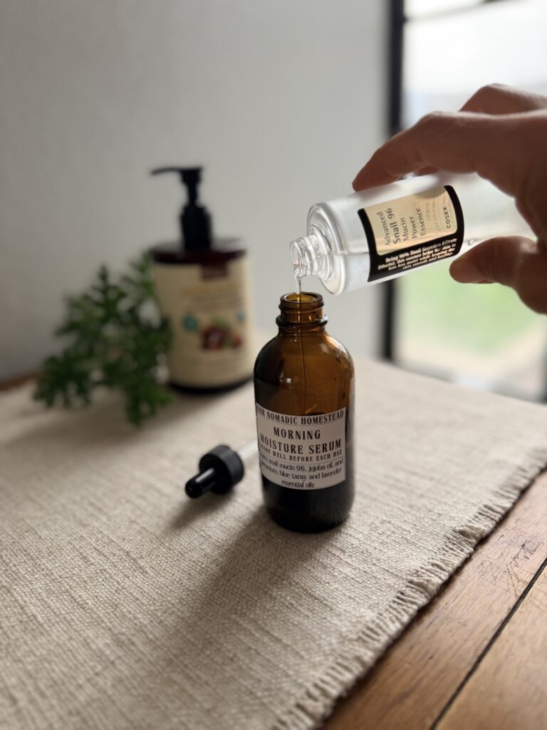 Pouring COSRX snail mucin essence into jojoba oil to make the serum