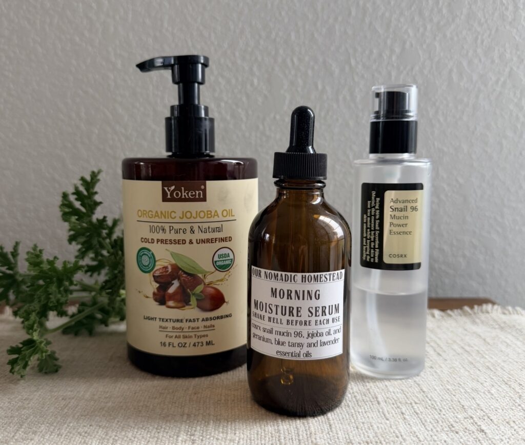 Ingredients for homemade snail mucin serum: jojoba oil, COSRX Advanced Snail 96 essence, and the finished serum in brown dropper bottle.