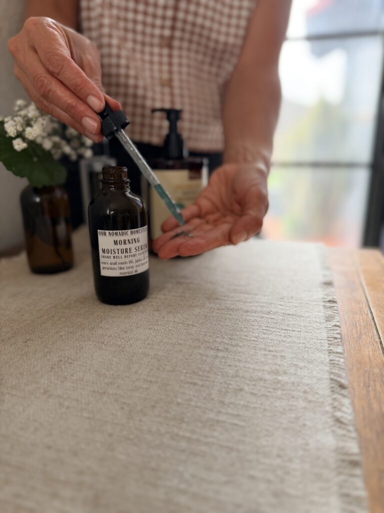 Applying Morning Moisture serum with a dropper, the blue tint from blue tansy