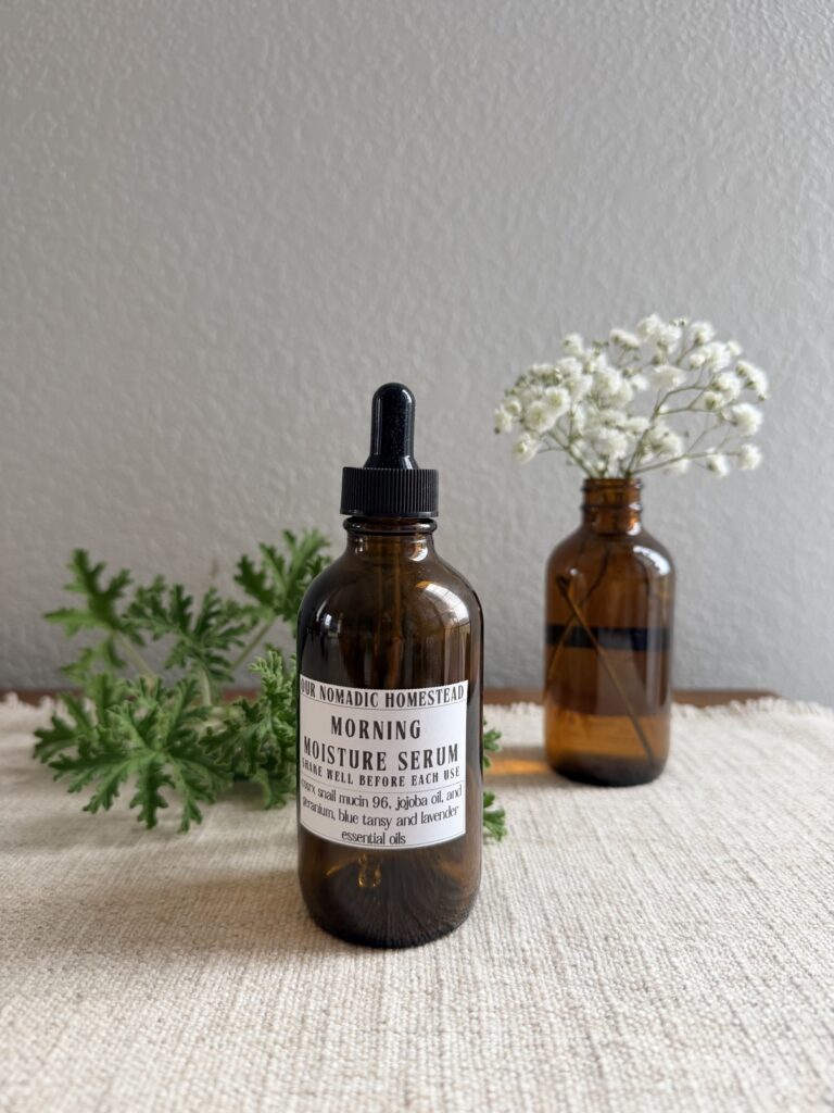 Morning Moisture snail mucin serum in an amber dropper bottle with a geranium leaf